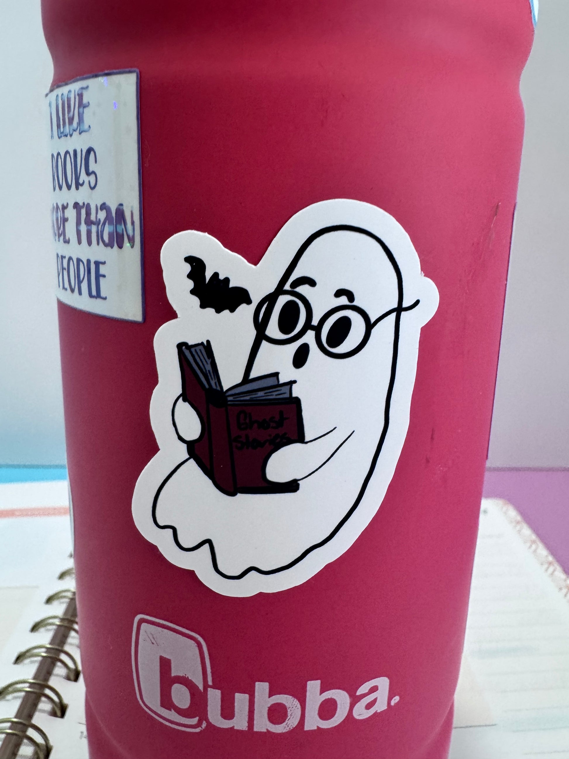 Hand drawn matte vinyl sticker of a cute ghost reading a book to a bat
